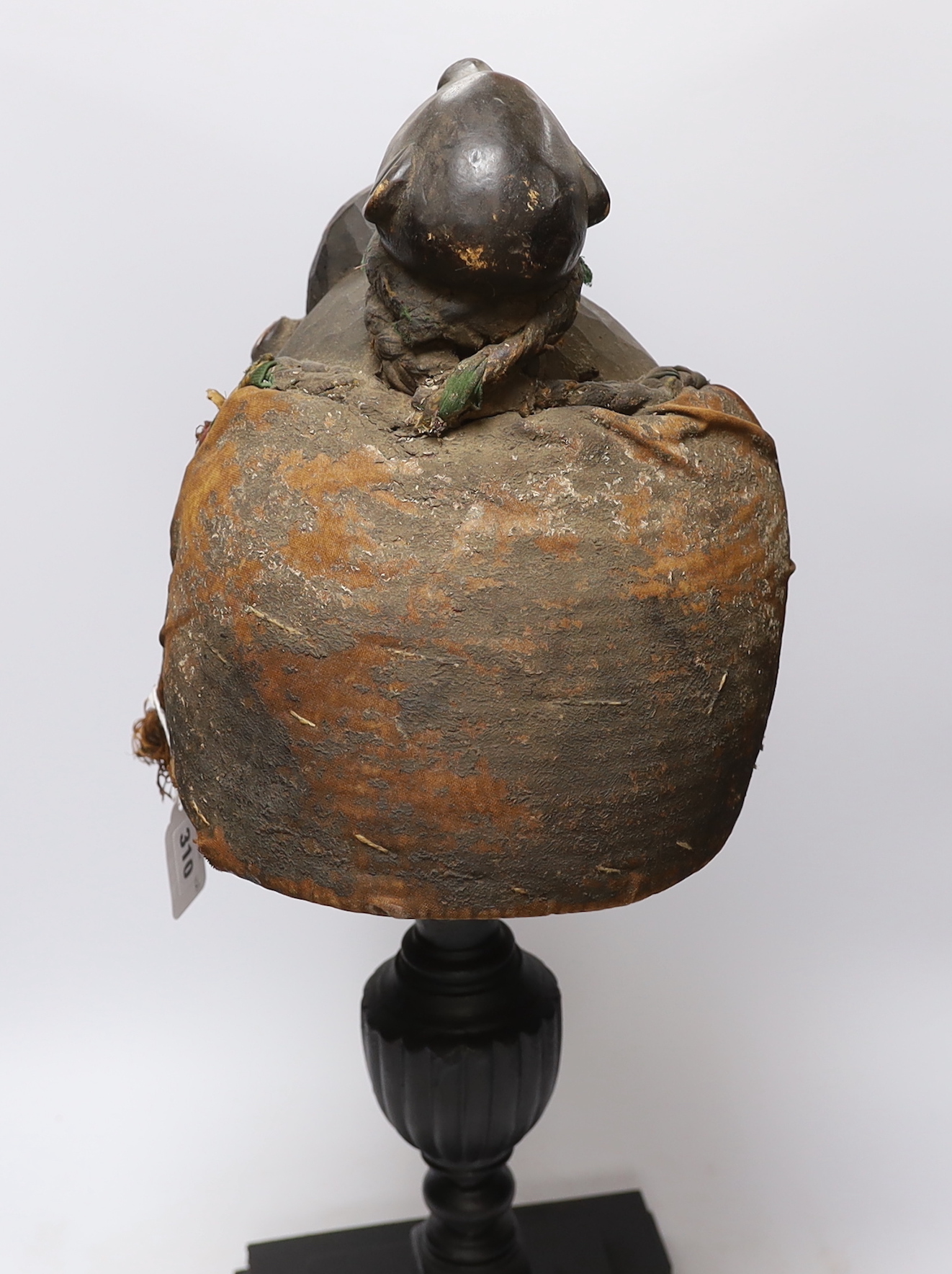 A West African carved wood helmet mask, possibly Kuba (Democratic Republic of Congo), with applied shells and glass inserts, on hardwood stand
